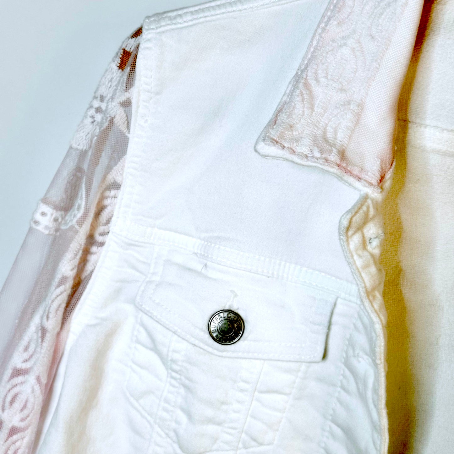 tinge of pink lace on a white jacket